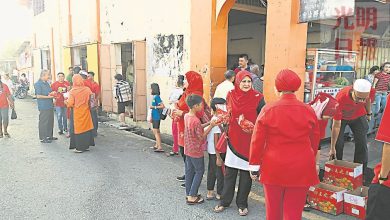 Photo of 日得拉舊鎮大街早市  土團成員穿紅衣派柑
