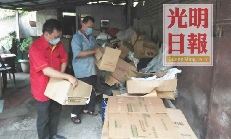 王松富（左）幫忙鄧祥和整理堆積如山的紙皮。