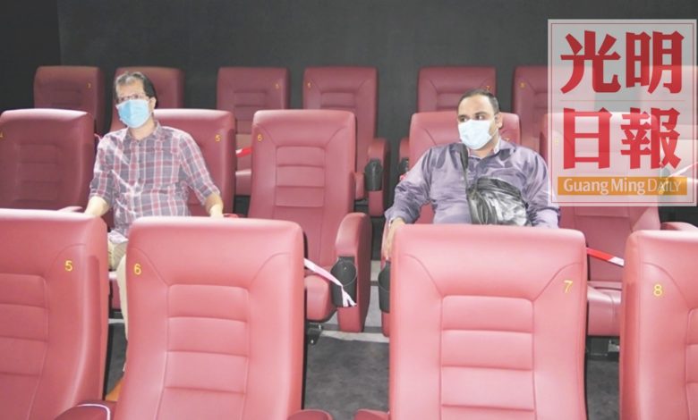 劉耀坤（左）與拉茲（右）向記者示範，到影院看戲必須分開坐的情景。