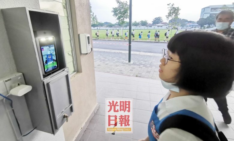 學生使用人臉識別自動測溫器測體溫及報到。