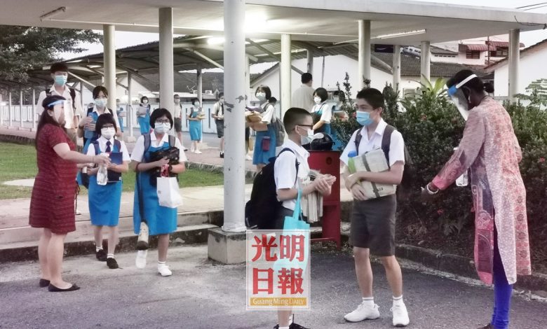 日新國民型中學逾2430名學生返校上課，在其中一個入口處，學生井然有序排隊等候測量體溫。