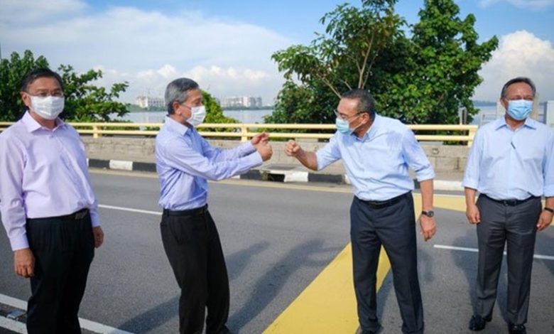 外交部長希山慕丁（右2）與新加坡外交部長維文（左2）互擊拳代替握手。
