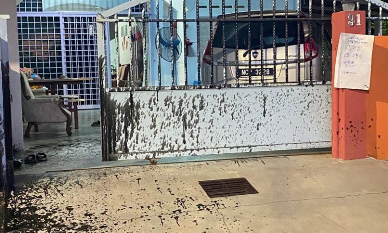 吳桂金起牀拜神時，發現住家大門被潑地滿地黑漆。