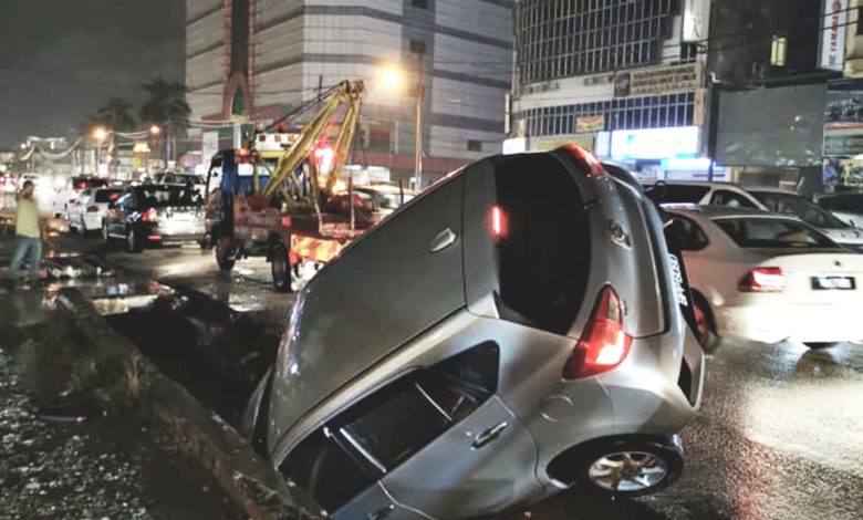 一輛車子誤墜入路邊溝渠，尾部高高翹起。（圖取自王詩棋臉書）

