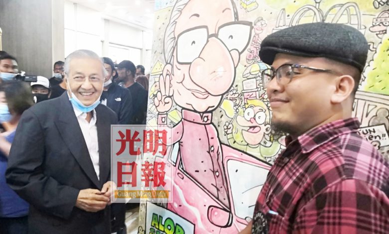 本地畫家瑪奇(右)以馬哈迪肖像著作,馬哈迪親自為畫作上簽名。