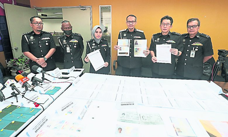 蘇芝拉（左三起）、峇哈魯丁和阿都拉欣展示起獲的偽造證件。左起是哈菲茲、阿努亞；右一是馬哈末。