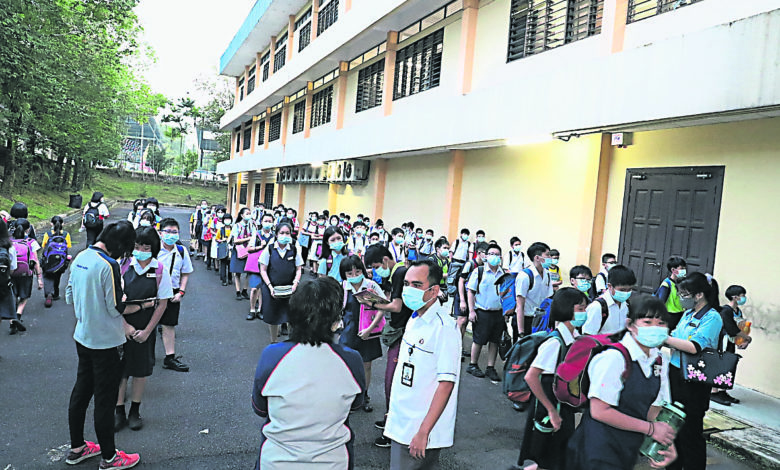 復課首日，教育局官員巡視國光一校的返校情況；學生排隊等候進入課室。
