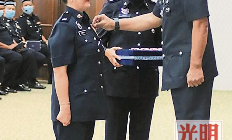 再努丁（右）頒發國家英雄勳章給女警官朱泉麗。