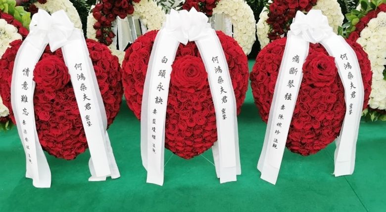 三位太太的心型玫瑰花圈並列放置靈堂中央。
