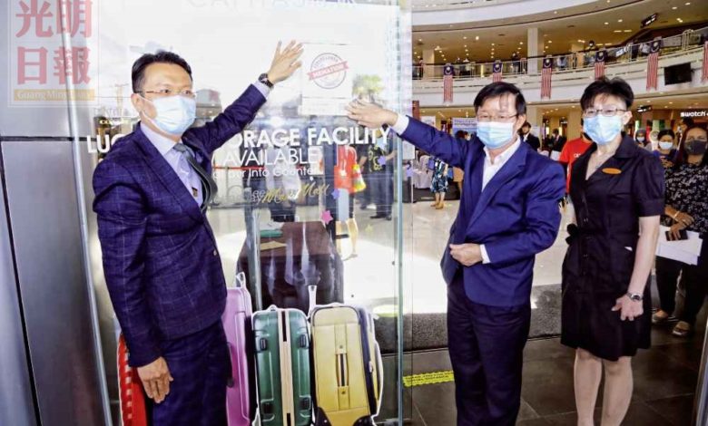 李思凌（右起）陪同曹觀友和楊順興為皇后灣廣場張貼“負責任旅遊”運動貼紙。
