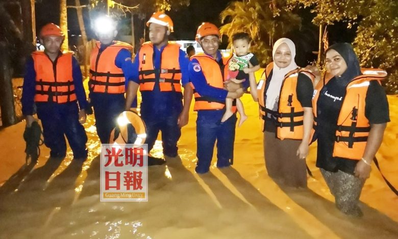 民防部隊在其中一個水深及腰的災區救出災民。