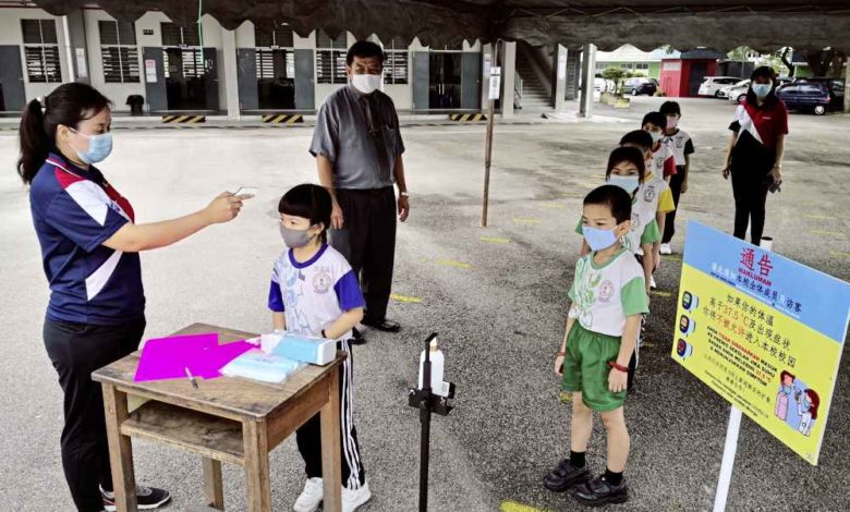 華民學校搭建測溫帳蓬，讓學生到校時排隊測量體溫後貼上貼紙；左一及左三為第二副校長張長茹及校長辜榮興；右一為第一副校長林瑜瑜。
