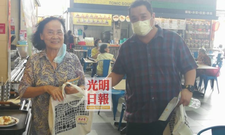 方龍興贈送新世界環保袋給80多歲的老顧客蘇女士。蘇女士說，新世界是檳城人的回憶，也是她和丈夫拍拖看戲享用美食地方