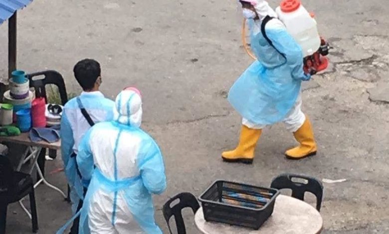 穿著防護衣的人員在組屋進行消毒工作。（圖取自Penang Kini臉書）