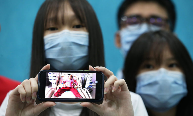 李貴松的子女向媒體展示手機上母親仍躺在病牀的照片。
