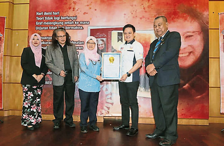 林天英（左二）在冠病期间撰写的诗集《跨越2020年大流行震动》荣获马来西亚记录大全颁发“最长的冠病诗歌”的认证。