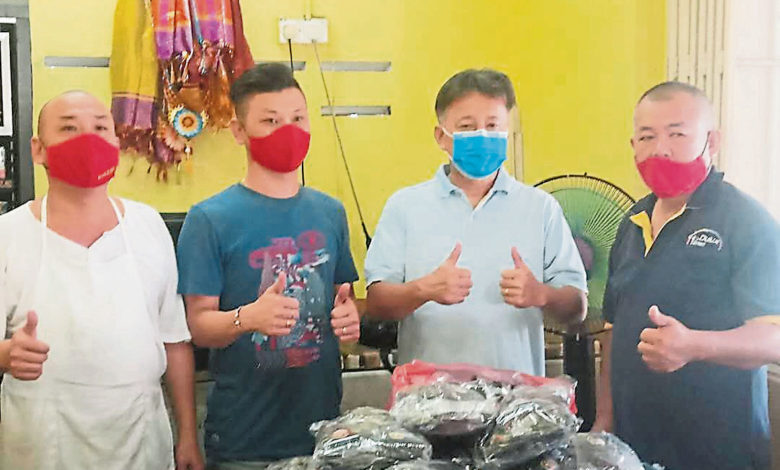 利滿施食團隊代表孔宏洲（右一）、孔俊平（左一）、潘偉南（左二）移交布制口罩予東華小學校長陳震翔。