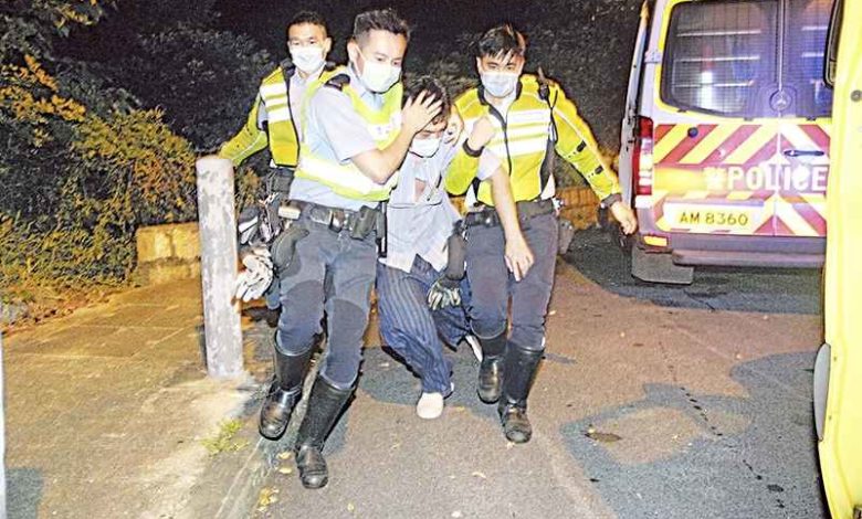 楊明離開座駕時明顯雙腿乏力，要兩位警員扶上警車。