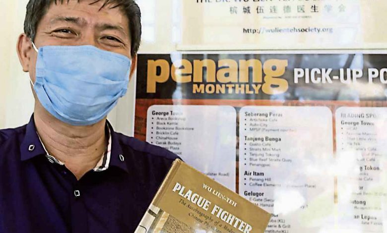 梁超明手持《鼠疫鬥士─伍連德自述》書籍。