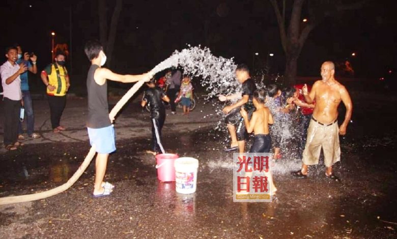 面對3天缺水後，孩童用消防車剩下的水洗澡玩樂。
