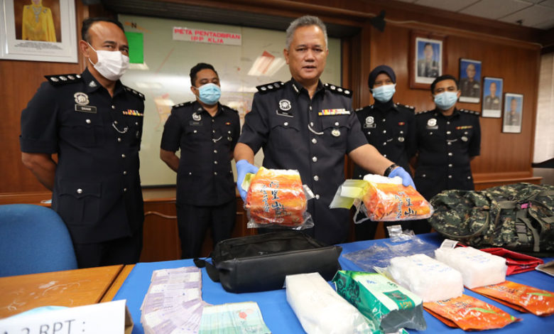 英然（左三）展示警方在逮捕2名華裔毒騾後，起獲1包重1.04公斤K他命及4包共重4.2公斤冰毒的包裝“毒茶”。