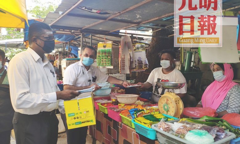 佳日星（左）和雷爾分派口罩予小販們。
