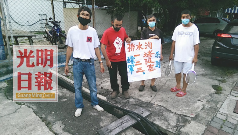 蔡倡蔚（左起）、鄭雨周、姚錠鴻（右）及另一名居民舉大字報，要求檳島市政廳嚴正看待民生問題。