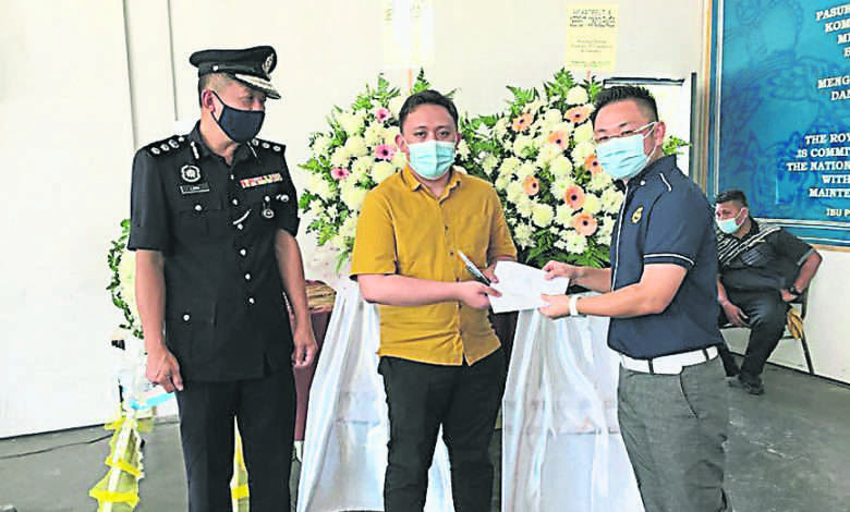 沈燕祥（右）在劉漢生（左）的陪同下，代表居鑾中華商會給予死者家屬慰問金。