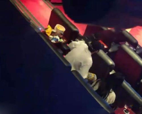 照片中一對男女坐在電影院中間，四處的確空無一人