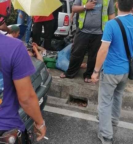 客貨車乘客躺在路肩等待救護車，熱心路人為他撐傘擋細雨。