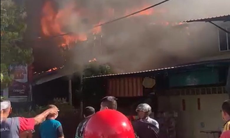 火焰衝天快速籠罩木板店屋，冒出駭人的滾滾濃煙。