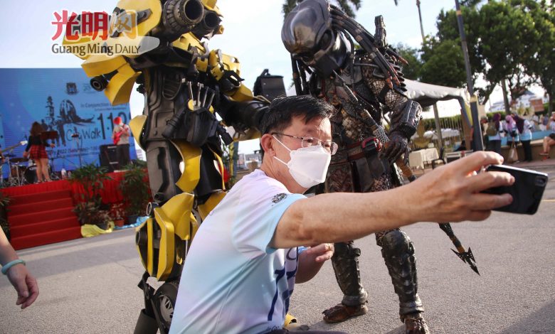 曹觀友在城市步行活動現場與變形金剛大黃蜂及鐵血戰士自拍。