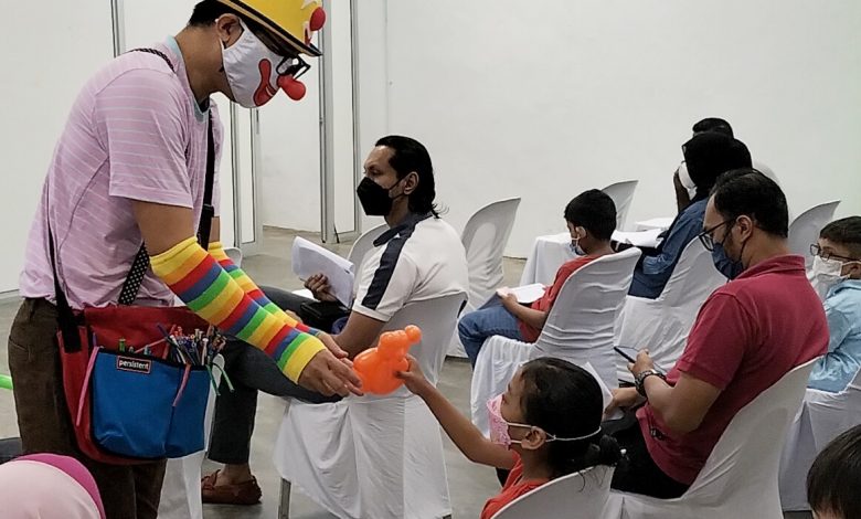 小丑在接種中心內派送氣球，孩童打針前的緊張情緒得以緩解。
