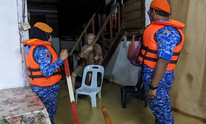 民房部隊成員給年長的受災居民提供援助。