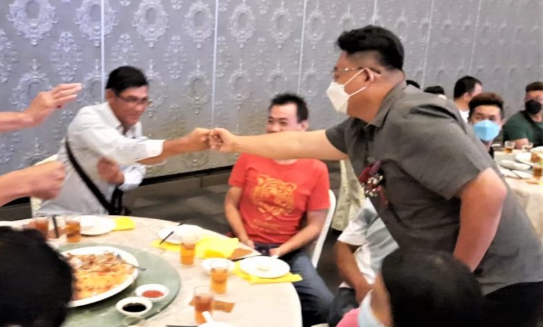 陳國鴻（右）到每一桌與出席者碰拳拜票，希望得到選民支持。