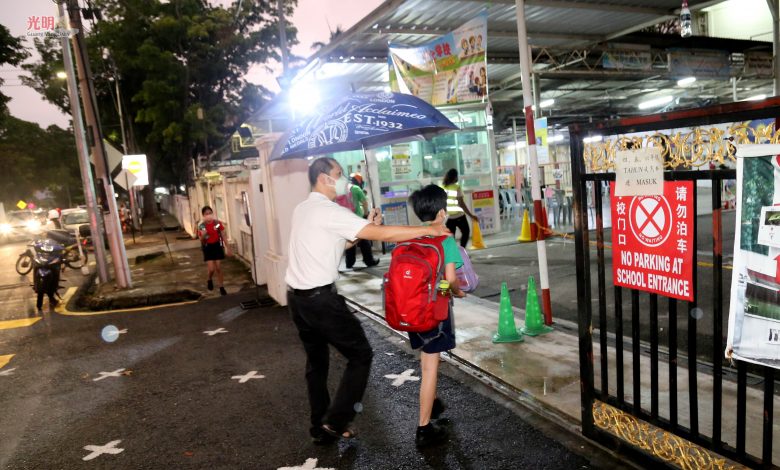 全體小學生返校上課日，商務小學的家長冒雨陪孩子到學校。