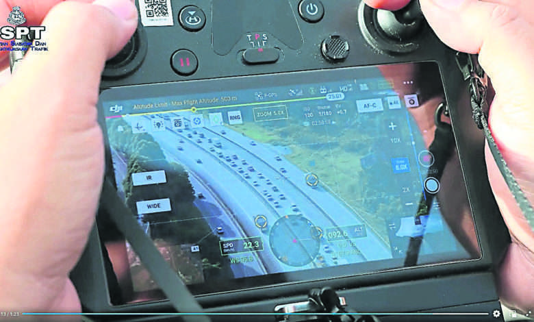 交警操縱無人機，螢幕顯示大道上的交通情況。