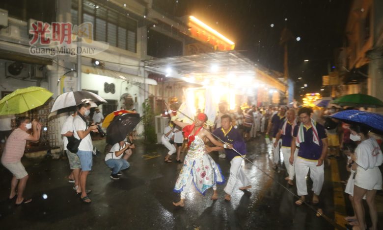 在香港巷斗母宮，穿著長針的乩童在現場跑動。