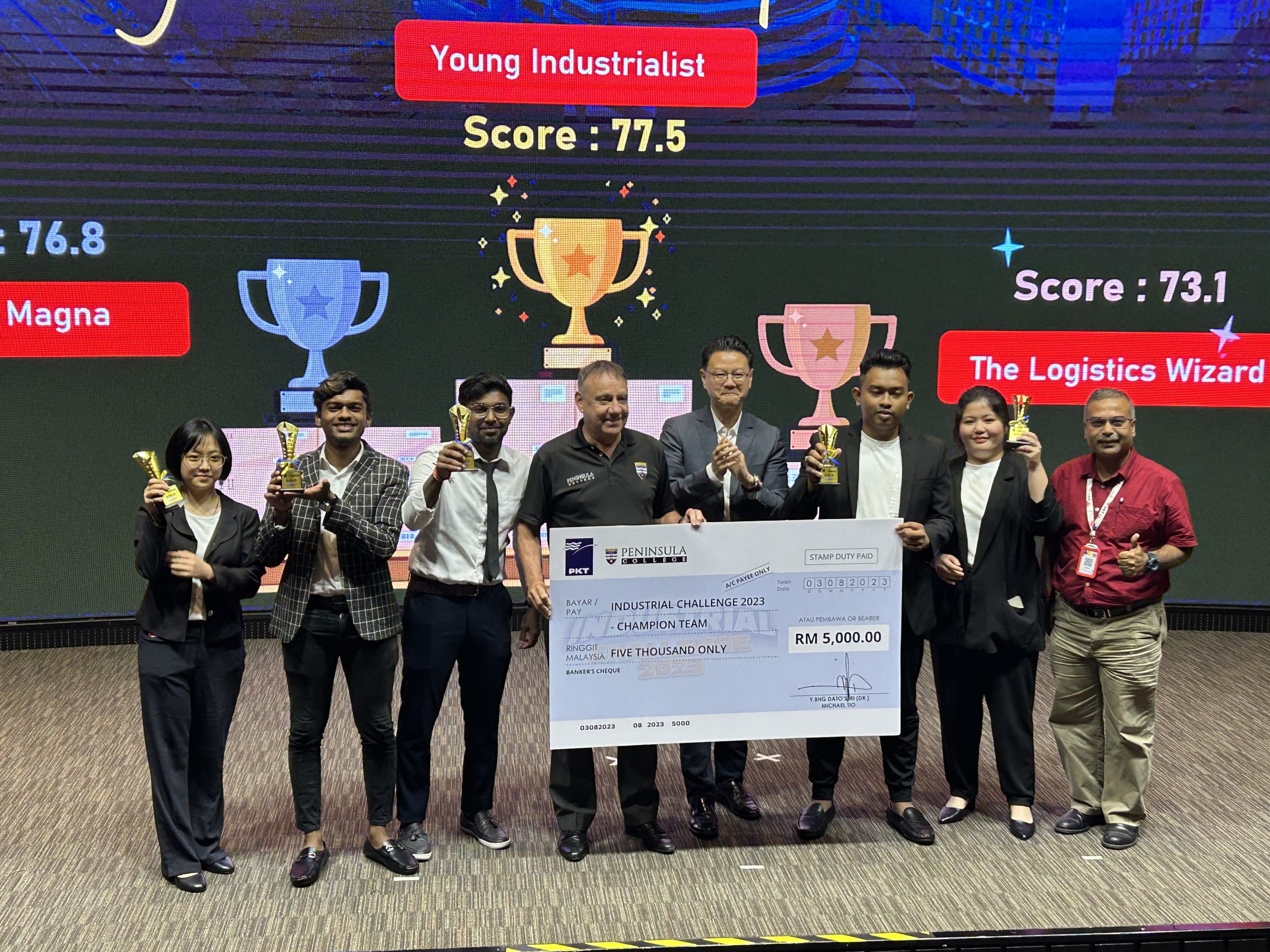 培能學院2023年工業挑戰競賽獲得第一名的Young Industrialists隊員，黃睬荋（左一起）、Kavithran A/L Magesan、Arisangar A/L Humapathi、導師Sivakumar Krishnan（右一起）、李雨楓、Pharadda Vishnu，領獎後與Ian Pashby（左四）及拿督斯里趙文耀（左五）合影。