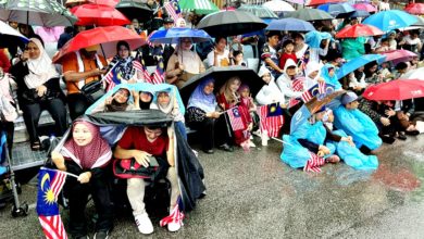 Photo of 甲民或撐傘或塑袋遮頭 雨水澆不息愛國之心