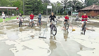 Photo of 籃球場雨後積水 學生騎腳車掃水