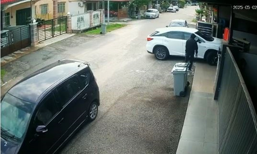入镜的匪徒快步进入白色被盗车子。(视频截图)