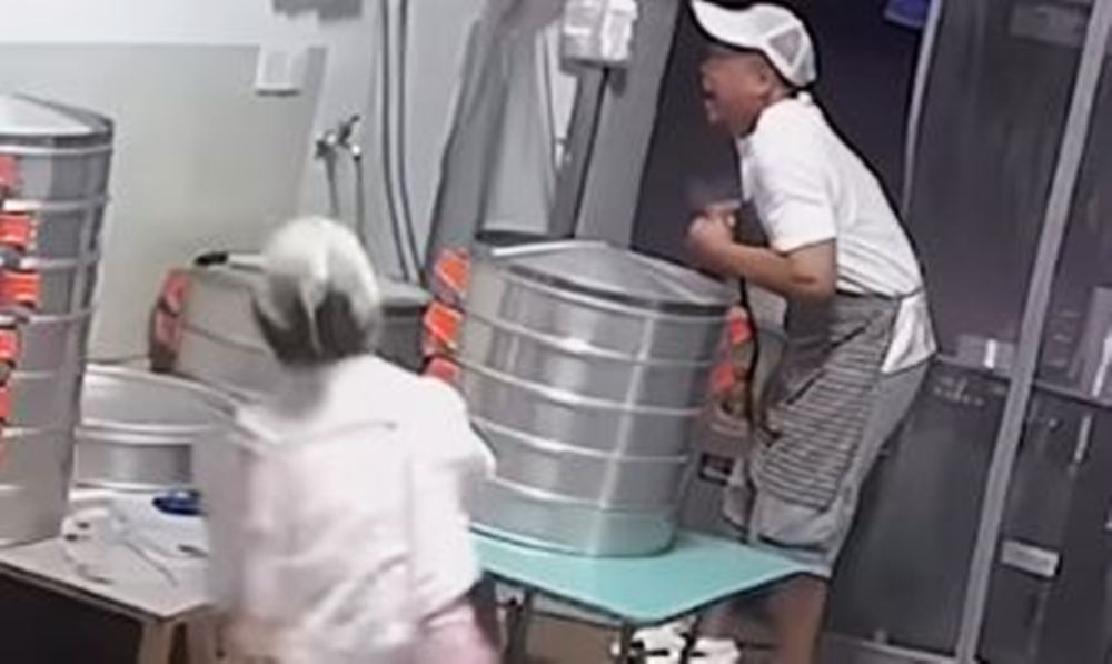 听到丈夫的呼救声，妻子反应敏捷，抄起塑料油桶冲向丈夫