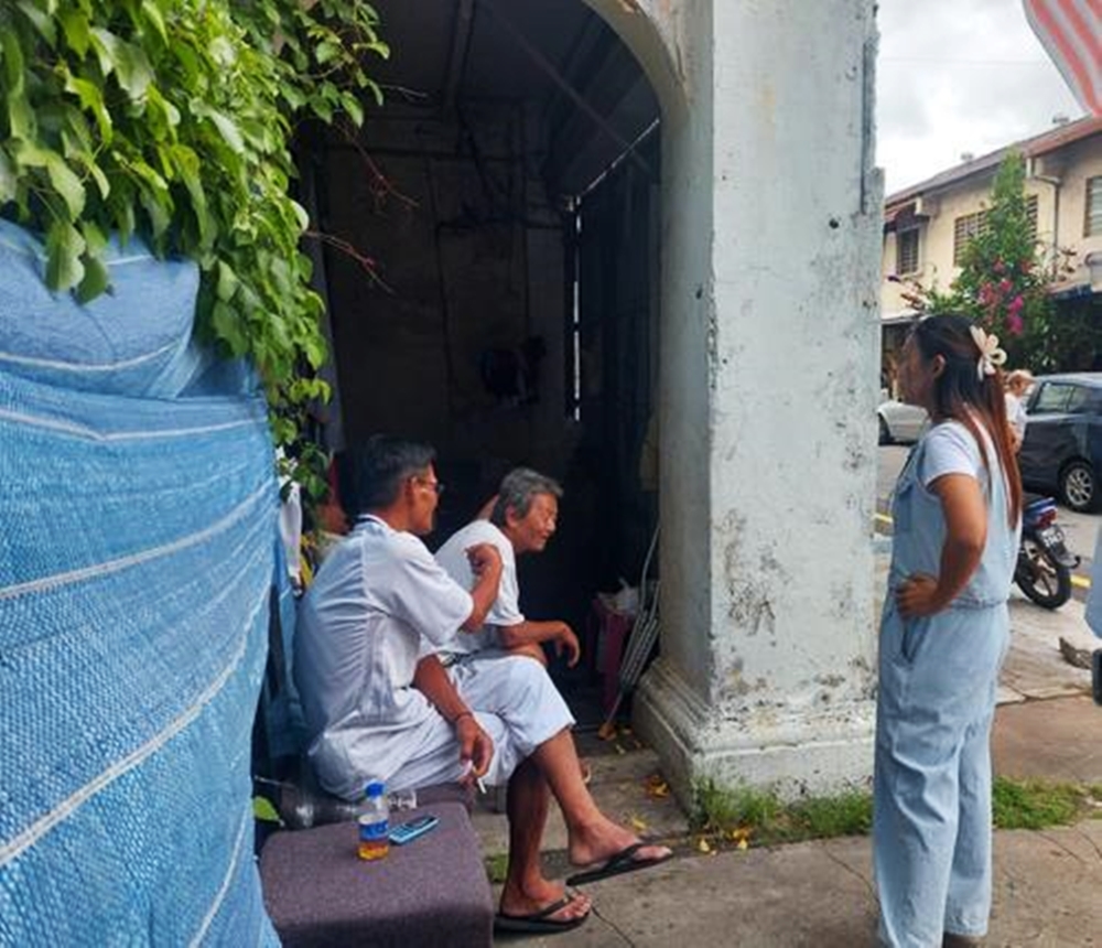 长者把荒屋走廊当避风港林朝雁（右）前往三宝井时，在场与二名露宿者谈天的友人，向林朝雁讲述二人的情况。（陈淑婷摄）