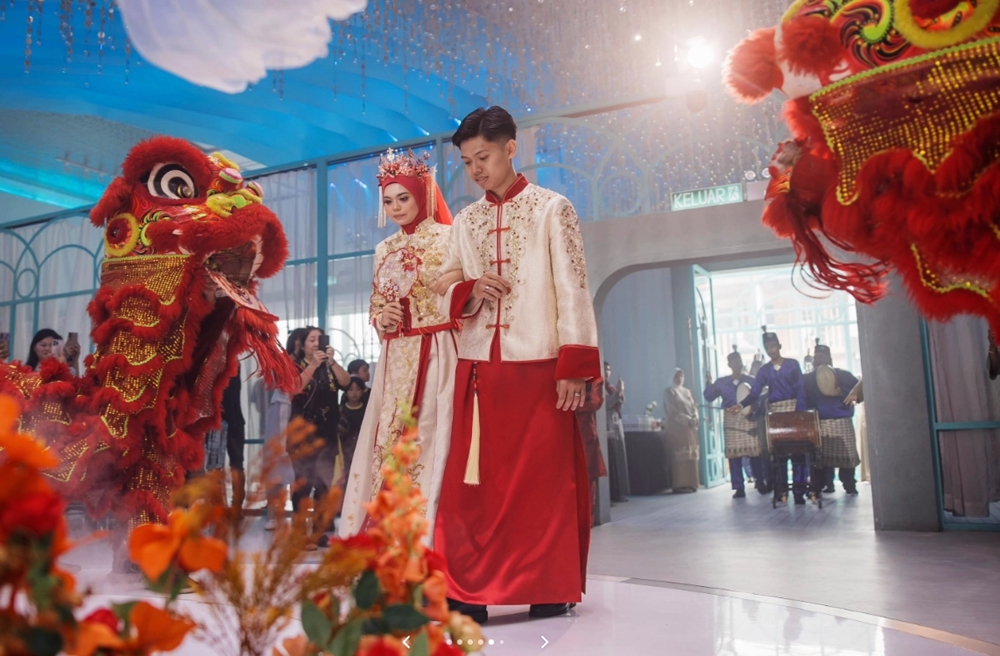 一对马来新人不仅身穿中式传统礼服登场，婚礼入场仪式更结合了马来传统乐器——羊皮鼓（kompang）和中华舞狮表演