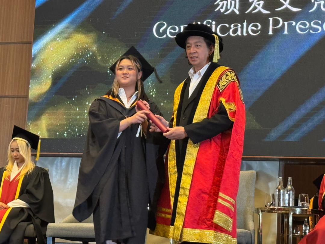 林福祥（右）颁发毕业証书给学生。