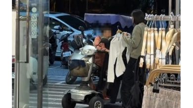 Photo of 老妇行动不便停在门外看 店员拿衣一件件供她挑