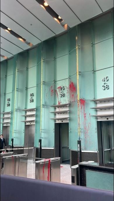 长江集团中心通一座电梯大堂，地面、升降机门和玻璃饰面，多处溅上红油。（文汇报照片）