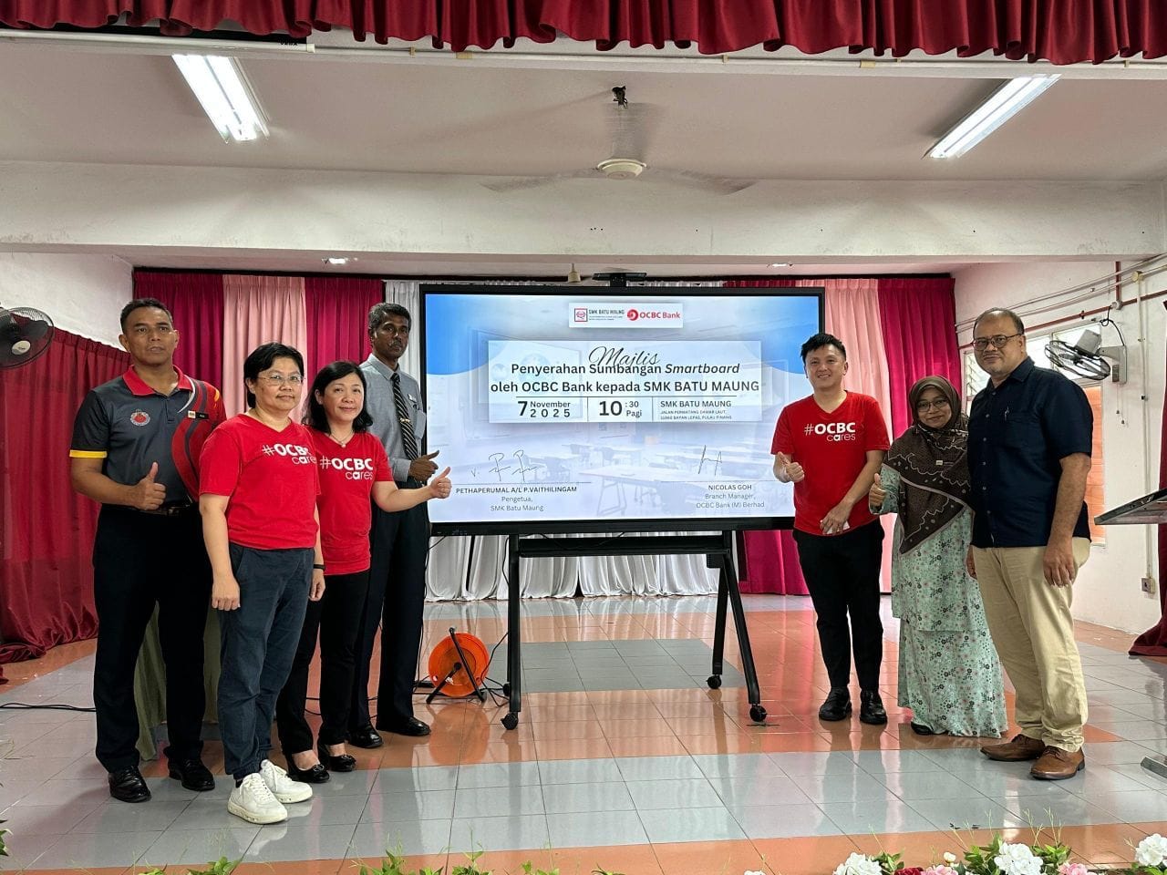 Nicholas Goh(右三)代表华侨银行捐赠智能白板予峇都茅国中校长彼达比鲁玛(左四)。