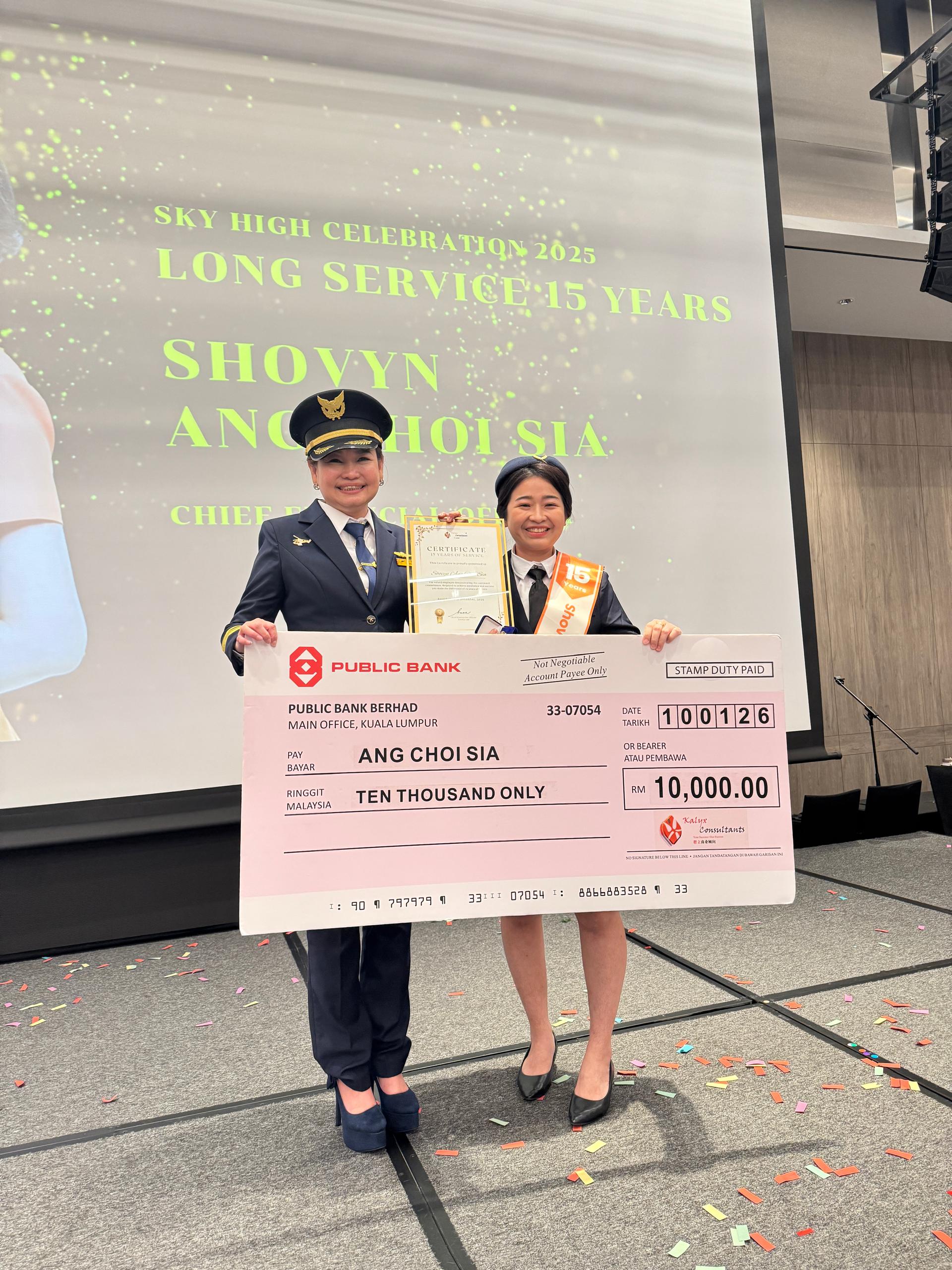拿督李抒芩颁发总值1万令吉的模型支票予忠诚员工奖(服务15年)得主洪翠霞。